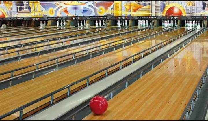 Bowling lanes with raised bumpers and a red ball.